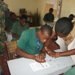 Teacher helps pupil fill out ballot